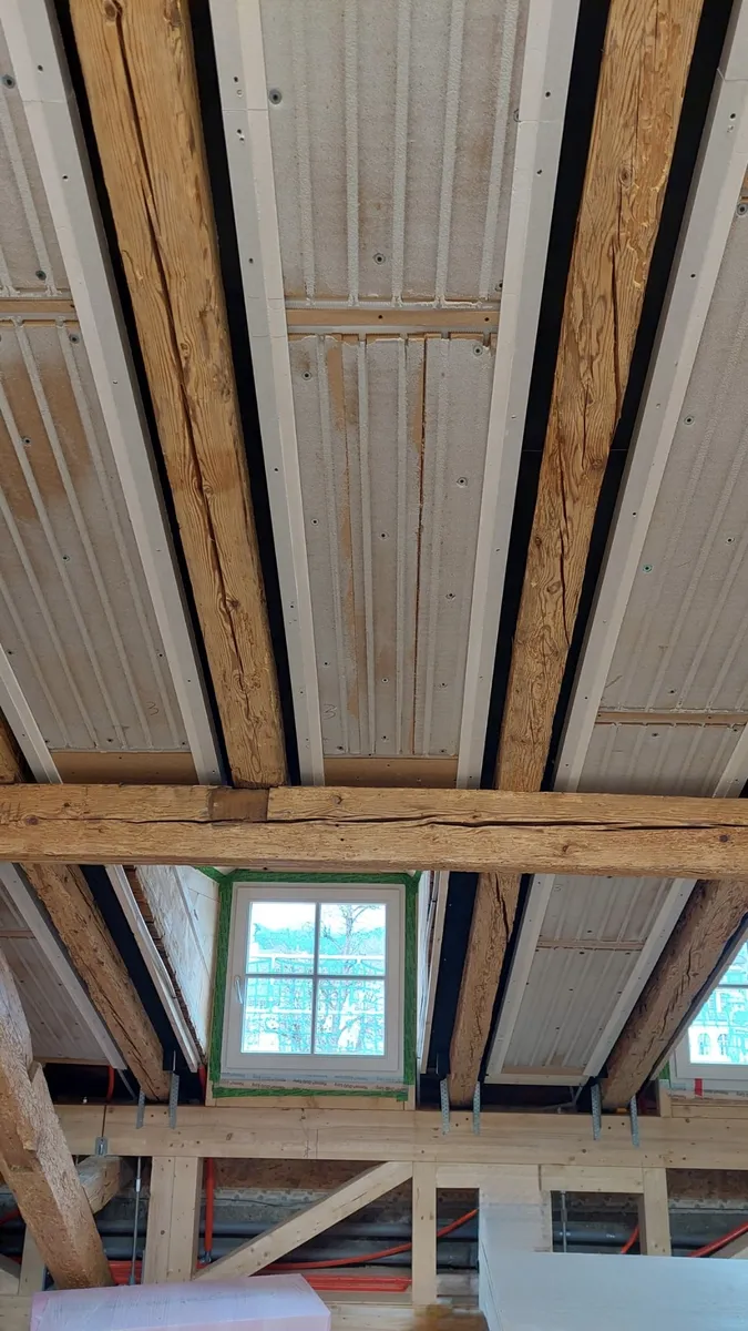 Vorher: Klimaplatten zwischen alten Holzbalken im Dachgeschoss