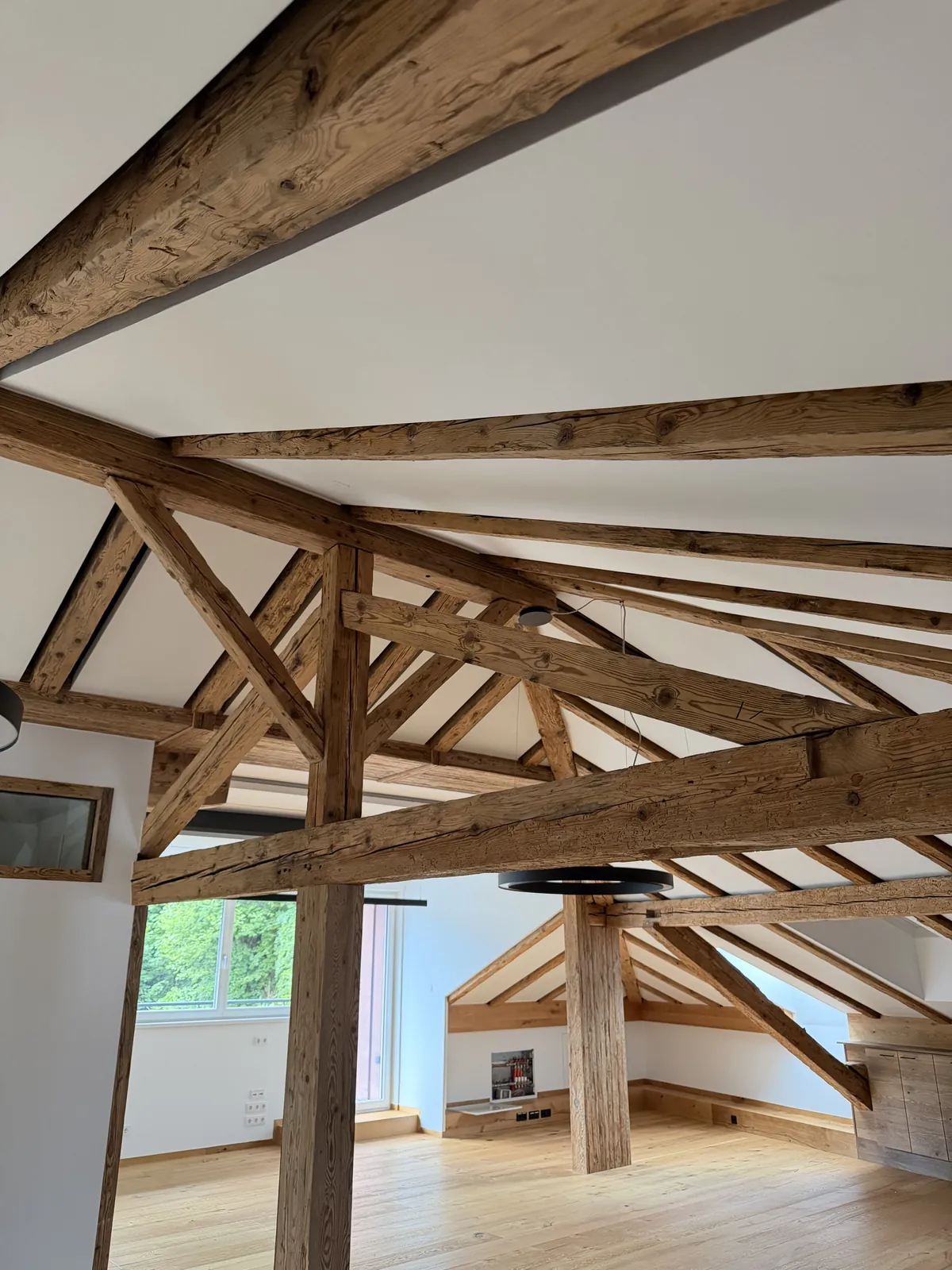 Fertige weiße Klimadecke zwischen freiliegenden Holzbalken